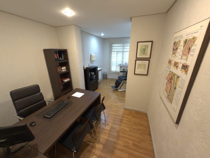 Vista da sala de atendimento, com a sala de exames ao fundo
